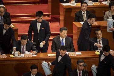 Chinese President Xi Jinping and other top leaders stand sit in the Great Hall of the People while their tea mugs are being filled ahead of the opening of the first session of the 13th Chinese People'...