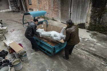 Workers load a cart with statues and busts of former Chinese leader Mao Zedong at the Jingdezhen Porcelain Factory.