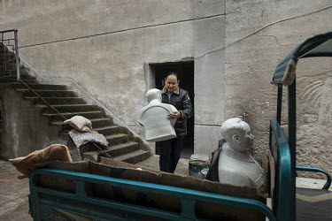Workers load a cart with statues and busts of former Chinese leader Mao Zedong at the Jingdezhen Porcelain Factory.