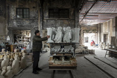 A worker unloads a cart of busts of former Chinese leader Mao Zedong after firing in a furnace inside a workshop at the Jingdezhen Porcelain Factory.