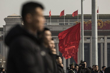 Red flags fly in the wind as attendants stand nearby out side of the Great Hall of the People after the opening of the first session of the 13th National People's Congress (NPC).
