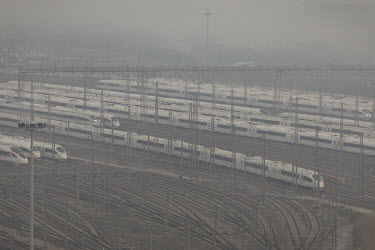 China Railway High-speed (CRH) trains, operated by China Railway Corp., sit in a train yard shrouded in haze on the outskirts of Shanghai.