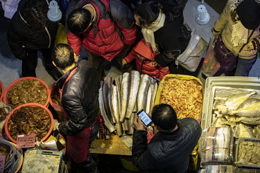 Attendees look at seafood displayed for sale at a Chinese New Year food exhibition.