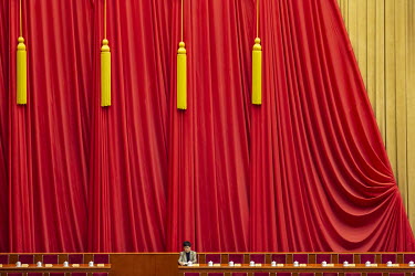 A delegate sits alone on stage in the Great Hall of the People ahead of the opening of the first session of the 13th Chinese People's Political Consultative Conference (CPPCC).