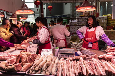 Workers sell seasoned pork meats at a Chinese New Year food exhibition.