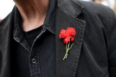 A protestor wearing a red carnation at a May Day demonstration by various trades unions and left wing political groups.