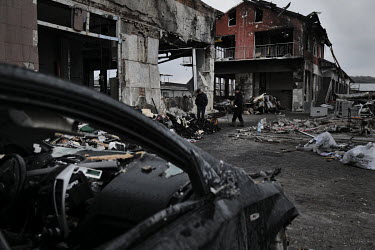 Two men clear the debris left after a Rusiian missile attack. On 18 April 2022 seven people were killed when four cruise missiles hit Lviv. Three were killed at this car repair workshop as they sat to...
