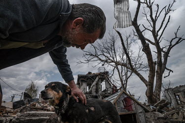 Viktor with Dick the dog. Dick is in a terrible way. He is timid, withdrawn and shaking. He has two large open wounds on his body. Viktor explained that he dug him out of the rubble that was their hou...