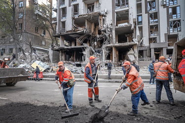 Workers clear the rubble after two cruise missiles landed in the night, killing a renowned Ukranian journalist and injuring a number of people.