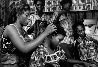 Women at an aid project working with single mothers, most have lost husbands and many were abducted and returned from the bush pregnant. Hairdressing is one skill always in demand and in a shack in th...