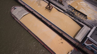 Grain being unloaded from a bulk transporter and loaded onto smaller river barges at the Nantong Cereals & Oils Transfer Co. facility at the Port of Nantong.