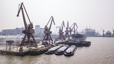 Grain being unloaded from a bulk transporter and loaded onto smaller river barges at the Nantong Cereals & Oils Transfer Co. facility at the Port of Nantong.