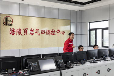 Workers operate operate in a control room at a shale gas collection and transfer facility at the Fuling shale gas project site, operated by Sinopec Chongqing Fuling Shale Gas Exploration and Developme...