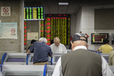 Elderly retail investors monitor and trade stocks at a security exchange house.