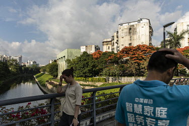 Residents walk over a bridge in the Luohu district.