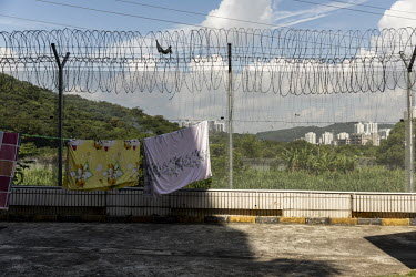 Blankets airing on a washing line attached to a barbed wire fence near the border with Hong Kong.