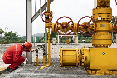 A worker checks meters on shale gas wells at the Fuling shale gas project site, operated by Sinopec Chongqing Fuling Shale Gas Exploration and Development Co., a unit of China Petrochemical Corp. (Sin...
