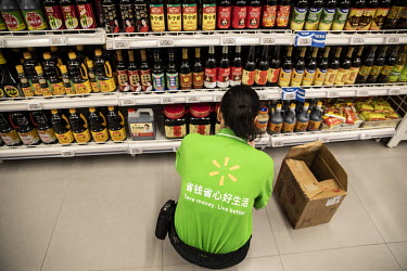 An employee stocks a shelf at a Walmart supermarket.