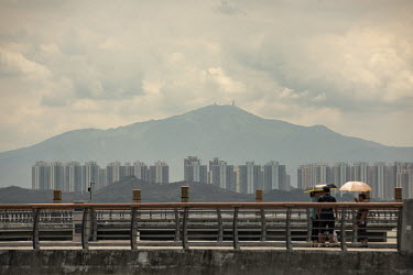 People on the Shenzhen Bay promenade with a view of the city beyond.