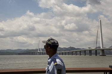 A security guard walks along the promenade near the Shenzhen Bay Bridge.