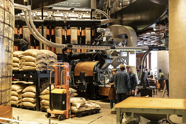 Employees stand in a coffee bean packaging line at the Starbucks Corp. Reserve Roastery store.