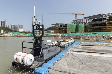A large unmanned surface vessel docked near the construction site for the aircraft carrier-like future headquarters of Oceanalpha Co. Oceanalpha is one of a handful of companies around the globe speci...
