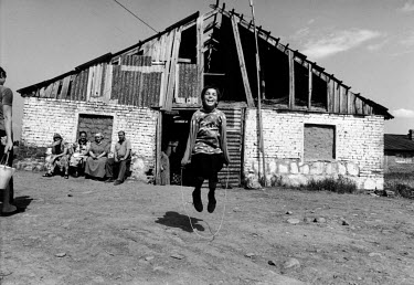 A girl skipping in Kolosok camp where even an old cowshed has become home to refugees, the animals have one half, and Chechens the other.