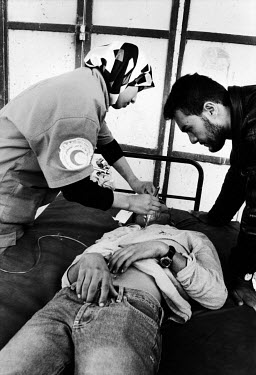 A medic treats a young man who has been injured to clashes with Israeli police at a border checkpoint.