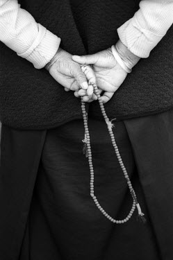 A Tibetan refugee holds a string of worry beads (Mala beads) in the Tashiling refugee camp.