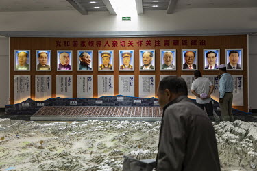 Visitors stand in front of portraits of past and present Chinese leaders inside a museum commemorating General Mu Shengzhong, also known as the father of the Qinghai-Tibet Highway. Golmud has grown in...