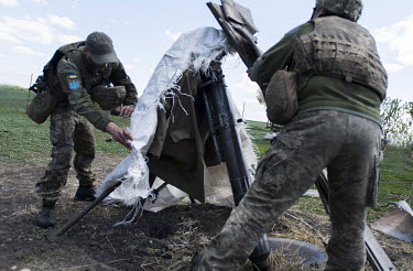 Soldiers prepare a mortar on the Ukrainian front lines facing the Russian held town of Izium.