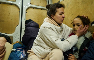 Katya comforts her son, who is feeling unwell, as they, along with other family members from a southern suburb of Rubizhne, squeeze on to evacuation transport to flee the city in a minibus organised b...