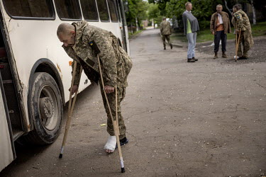 A wounded soldier enters a bus after initial treatment at a military hospital in an undisclosed location close to the frontline has stabilised his injuries. He, and colleagues, are being transported t...