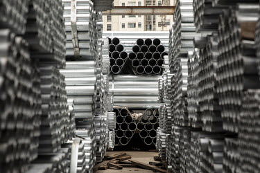 Piles of steel piping at a metals stockyard.