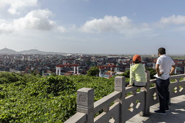 A man and his child on a viewing platform overlooking the Yangshan Deep Water Port.