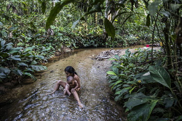 Walkanga bathing with her little brother in a small stream.   The native peoples of the Amazon have a holistic vision of the Pachamama: "It is not simply a landscape or aesthetic relationship, but the...
