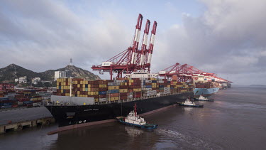 The Soro Enshi container ship, operated by Maersk, gets help from tug boats as it prepares to sail from Yangshan Deep Water Port.