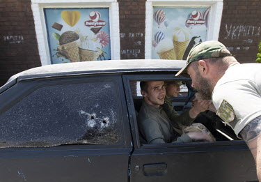 Ukrainian Soldiers in a bullet marked vehicle outside a small shop in the village of Malaky, on the Siverskyi Donets River. A frontline village facing the Russian advance on Lyman from Russian held Si...