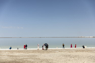 Visitors stand on the banks of an evaporation pond operated by Qinghai Salt Lake Industry Co. in the Chaerhan Salt Lake. Qinghai Salt Lake produces potash fertilizers, potassium chloride and lithium c...