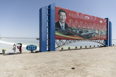 A propaganda poster featuring Chinese President Xi Jinping beside an evaporation pond operated by Qinghai Salt Lake Industry Co. in the Chaerhan Salt Lake. Qinghai Salt Lake produces potash fertilizer...