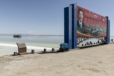 A propaganda poster featuring Chinese President Xi Jinping beside an evaporation pond operated by Qinghai Salt Lake Industry Co. in the Chaerhan Salt Lake. Qinghai Salt Lake produces potash fertilizer...