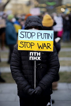 A Ukrainian activist in front of the Chancellor's office holding a placard that reads: 'Stop Putin Stop War', following the Russian military invasion of Ukraine.