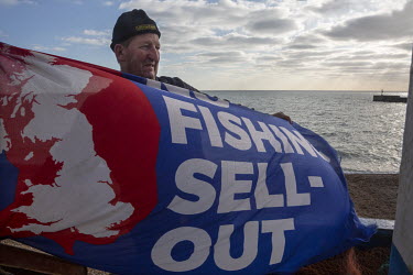 Fisherman Stuart Hamilton raises a flag on his boat, protesting about the reality of the Brexit deal and how it has affected the British fishing industry.