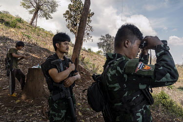 Min Thar (centre), a former banquets and events worker at the Lotte Hotel in Yangon who joined the People's Defence Force (PDF), looks over Myanmar Army frontline positions from the closest frontline...