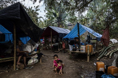 Karen IDPs, who were forced from their homes by Myanmar Army attacks on Lay Kay Kaw, sit outside their huts in an IDP camp in an undisclosed location in Karen State.