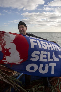 Fisherman Stuart Hamilton raises a flag on his boat, protesting about the reality of the Brexit deal and how it has affected the British fishing industry.