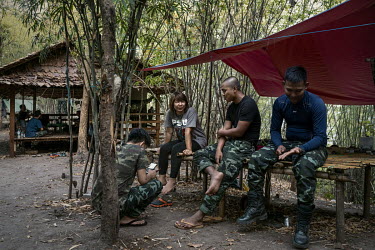 Naw Bway Wahy (3rd from right), a former midwife who joined the People's Defence Force (PDF) as a medic, sits and talks with other soldiers from the PDF in their camp in an undisclosed location in Kar...