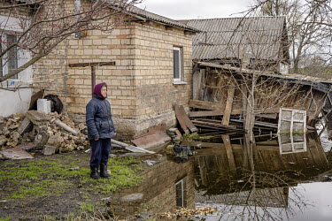 Valentyna, a local resident of Demydiv, looks at the floodwaters which ruined her home but which are now starting to recede. The cause of the current flooding is not clear with speculation that it was...