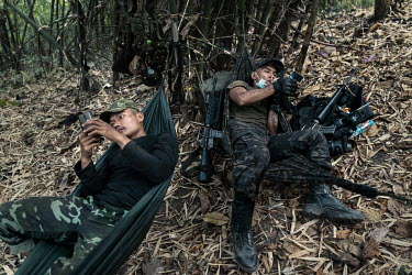 Soldiers from the DKBF, a Karen ethnic armed group, rest and setup their hammocks in a defensive perimeter around the People's Defense Force (PDF) camp where they are staying in an undisclosed locatio...