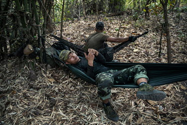 Soldiers from the DKBF, a Karen ethnic armed group, rest and setup their hammocks in a defensive perimeter around the People's Defense Force (PDF) camp where they are staying in an undisclosed locatio...